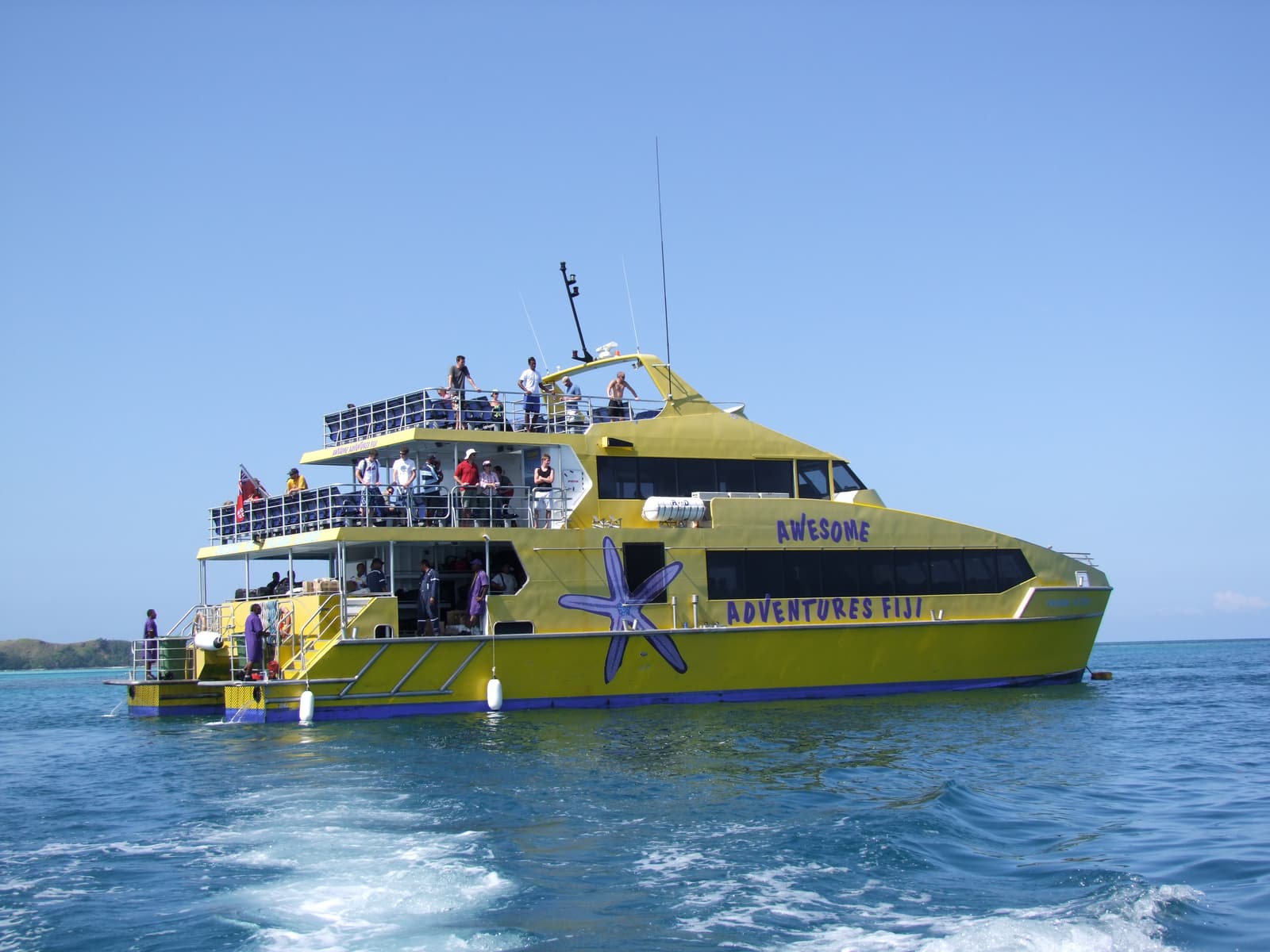 A yellow high-speed catamaran at sea in Fiji